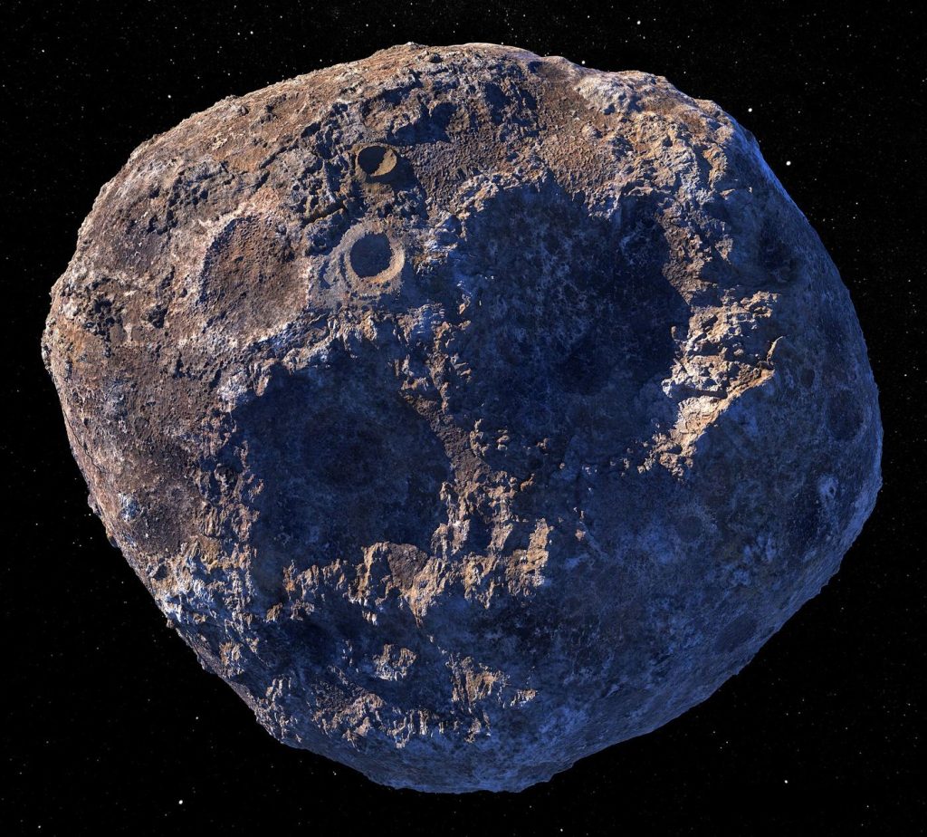 A rugged asteroid drifts against a dense field of bright stars in deep space.